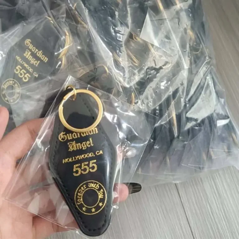 Custom black motel-style keychains with gold lettering and gold key rings, individually packed in clear OPP bags for protection and presentation.