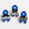 Three custom blue awareness ribbon enamel pins featuring black mustaches, polished silver-tone outlines, and “Let it grow!” lettering in three different designs.