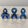 Three custom blue awareness ribbon enamel pins featuring black mustaches, polished silver-tone outlines, and “Let it grow!” lettering in three different designs.