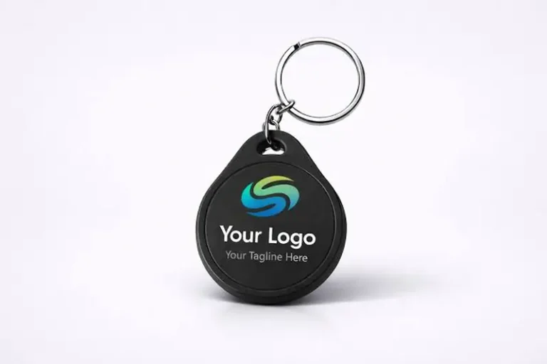 A custom black teardrop-shaped NFC access keychain with a colorful printed company logo, personalized tagline, silver metal split ring, and compact plastic body.