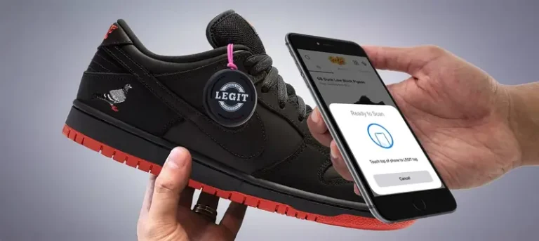 A black sneaker with red outsole featuring a round LEGIT NFC authentication tag, held near a smartphone displaying a contactless product verification screen.