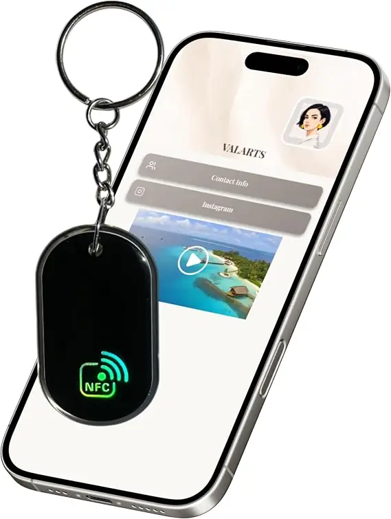 A custom black NFC social media keychain with silver metal ring, glowing NFC symbol, and smartphone displaying a digital business card with contact information, Instagram link, and video preview.